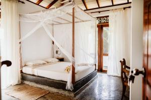 1 dormitorio con 1 cama con dosel en Amuura Beach Villa, en Beruwala