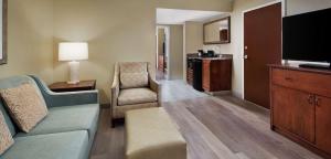 a living room with a couch and a flat screen tv at Embassy Suites by Hilton Destin Miramar Beach in Destin