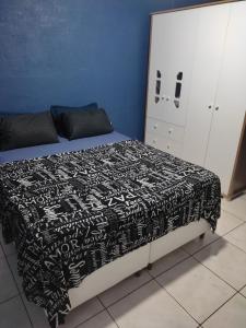1 dormitorio con 1 cama con manta blanca y negra en Gray House 3 - JD. Leonor en Londrina