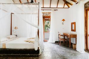 een slaapkamer met een bed en een bureau bij Amuura Beach Villa in Beruwala