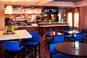 um restaurante com cadeiras e mesas azuis e um bar em Courtyard Cleveland Airport North em North Olmsted