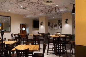 Embassy Suites Fort Worth - Downtown في فورت وورث: غرفة طعام مع طاولات وكراسي خشبية