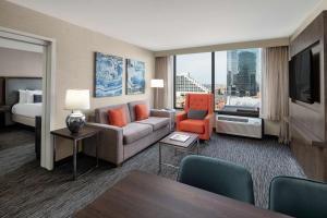 Habitación de hotel con sofá y cama en Embassy Suites Fort Worth - Downtown en Fort Worth