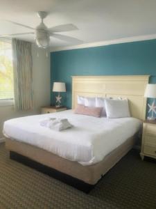 a bedroom with a large white bed with a blue wall at Seawatch at Island Club by Capital Vacations in Hilton Head Island