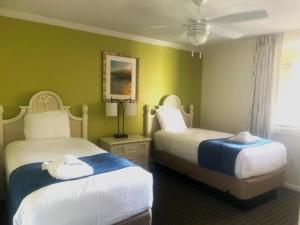 two beds in a room with green walls at Seawatch at Island Club by Capital Vacations in Hilton Head Island