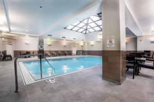 a large swimming pool in a building with a restaurant at Hilton Indianapolis Hotel & Suites in Indianapolis