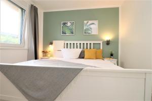 - une chambre avec un grand lit blanc et des oreillers jaunes dans l'établissement Haus am Meer Haus am Meer, App 01, à Neuhaus