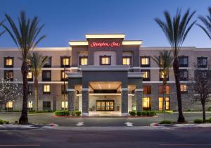 a hotel with palm trees in front of a building at Hampton Inn Los Angeles Orange County Cypress in Cypress