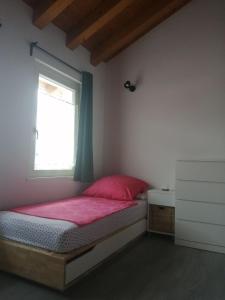 een slaapkamer met een rood bed en een raam bij Appartamento Veses in Santa Giustina