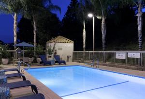 a swimming pool at night with palm trees at Hampton Inn Los Angeles Santa Clarita in Santa Clarita