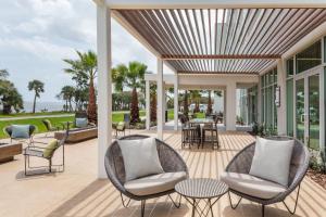 a patio with wicker chairs and tables on a deck at Courtyard By Marriott Titusville Kennedy Space Center in Titusville