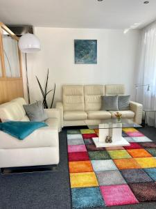 a living room with two couches and a colorful rug at Glads Apartment in Feldkirch