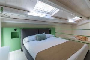 sypialnia z dużym łóżkiem i oknem dachowym w obiekcie Il Timbro - Dimore Diffuse w mieście Vasto