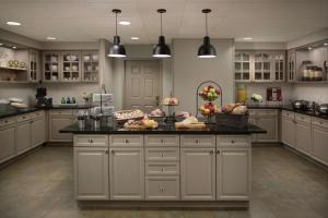a large kitchen with a counter with food on it at Homewood Suites by Hilton Lubbock in Lubbock