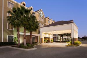 una representación de la parte delantera de un hotel con palmeras en Homewood Suites Lafayette-Airport en Lafayette