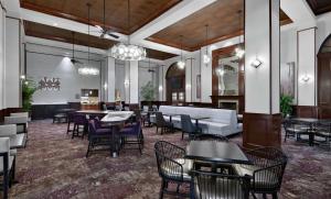 a lobby with tables and chairs and a bar at Homewood Suites Lafayette-Airport in Lafayette