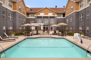 uma imagem de uma piscina num hotel com mesas e cadeiras em Homewood Suites by Hilton Mahwah em Mahwah