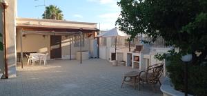 eine Terrasse mit Stühlen, einem Tisch und einem Sonnenschirm in der Unterkunft Casa vacanze Agrumeto in Latiano