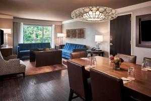 a living room with a table and a dining room at The StateView Hotel, Autograph Collection in Raleigh