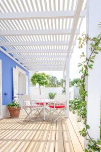 uma pérgola branca num pátio com uma mesa e cadeiras em Casa Sofia no Carvalhal