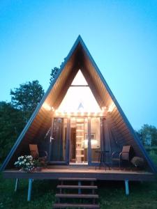 a frame house with a pitched roof with a porch at Rose Valley Cottage in Ieriķi