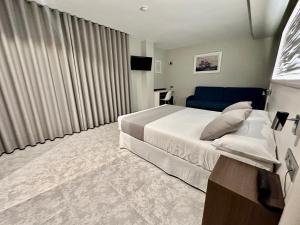 - une chambre avec un grand lit et un canapé bleu dans l'établissement Hotel El Paraíso, à Calabardina