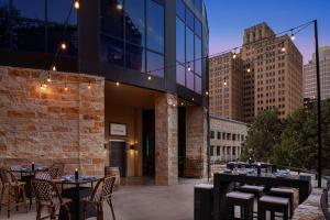 un patio con mesas y sillas y un edificio en Embassy Suites San Antonio Riverwalk-Downtown en San Antonio