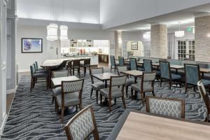 a dining room with tables and chairs and a bar at Homewood Suites by Hilton Seattle-Tacoma Airport/Tukwila in Tukwila