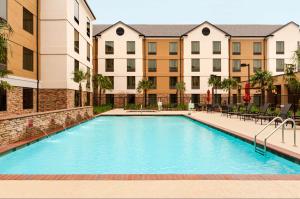 uma imagem de uma piscina num complexo de apartamentos em Hilton Garden Inn Shreveport Bossier City em Bossier City