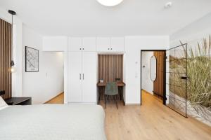 Un dormitorio con una cama blanca y un escritorio. en Modernes Studio am Bremer Dom mit Balkon, en Bremen 18 fotos más