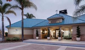 a house with a blue roof and palm trees at Homewood Suites by Hilton San Jose Airport-Silicon Valley in San Jose