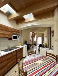 eine Küche mit einem Tisch und einem Waschbecken sowie ein Zimmer in der Unterkunft maison de tourisme aux sables d'olonne in Les Sables-dʼOlonne