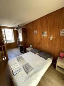 ein großes Bett in einem Zimmer mit Holzwänden in der Unterkunft maison de tourisme aux sables d'olonne in Les Sables-dʼOlonne
