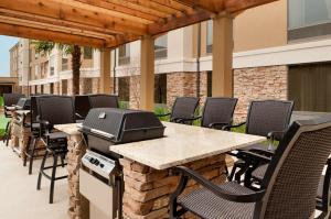 a grill on a patio with chairs and a table at Homewood Suites by Hilton Shreveport Bossier City, LA in Bossier City