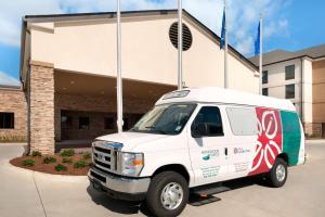 un furgone bianco parcheggiato di fronte a un edificio di Homewood Suites by Hilton Shreveport Bossier City, LA a Bossier City