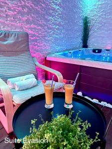 two drinks on a table next to a bath tub at Lovely in Neuf-Mesnil