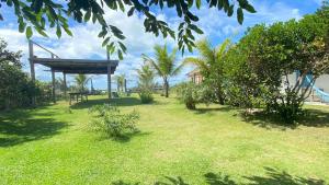 a park with a bench and trees and grass at Pousada Iemanja in Caraíva