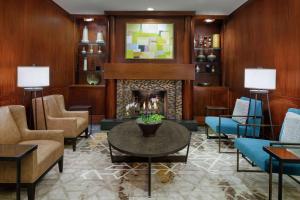 a living room with a fireplace and blue chairs at DoubleTree Suites by Hilton Charlotte/SouthPark in Charlotte