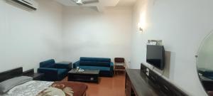a room with two blue chairs and a flat screen tv at Hotel Surya inn in Raipur