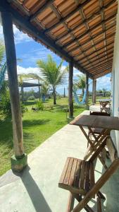 a picnic table and a bench on a patio at Pousada Iemanja in Caraíva