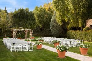an outdoor wedding ceremony with white chairs and an arch at DoubleTree by Hilton Paradise Valley Resort Scottsdale in Scottsdale