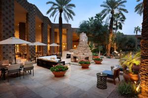 d'une terrasse avec un foyer extérieur et des palmiers. dans l'établissement DoubleTree by Hilton Paradise Valley Resort Scottsdale, à Scottsdale