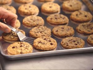 una persona sosteniendo una espátula en una bandeja de galletas en DoubleTree by Hilton New Orleans en Nueva Orleans