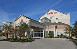 uma vista frontal de um hospital com palmeiras em Hilton Garden Inn Covington/Mandeville em Covington