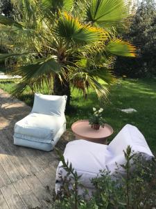 two white chairs and a table in a yard at Tenuta i rosoni in Cursi