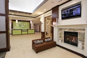 a living room with a tv and a couch and a fireplace at Hilton Garden Inn Covington/Mandeville in Covington