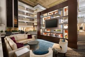 a lobby of a hotel with couches and a tv at Embassy Suites by Hilton Atlanta Airport in Atlanta