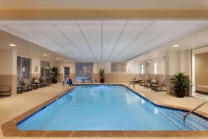 duży basen w holu z krzesłami w obiekcie Embassy Suites by Hilton Atlanta Airport w Atlancie