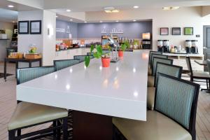 Hampton Inn Vero Beach Outlets في فيرو بيتش: طاولة بيضاء كبيرة وكراسي في مطعم