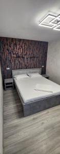 1 dormitorio con cama y pared en EFM ONE, en Brezoi